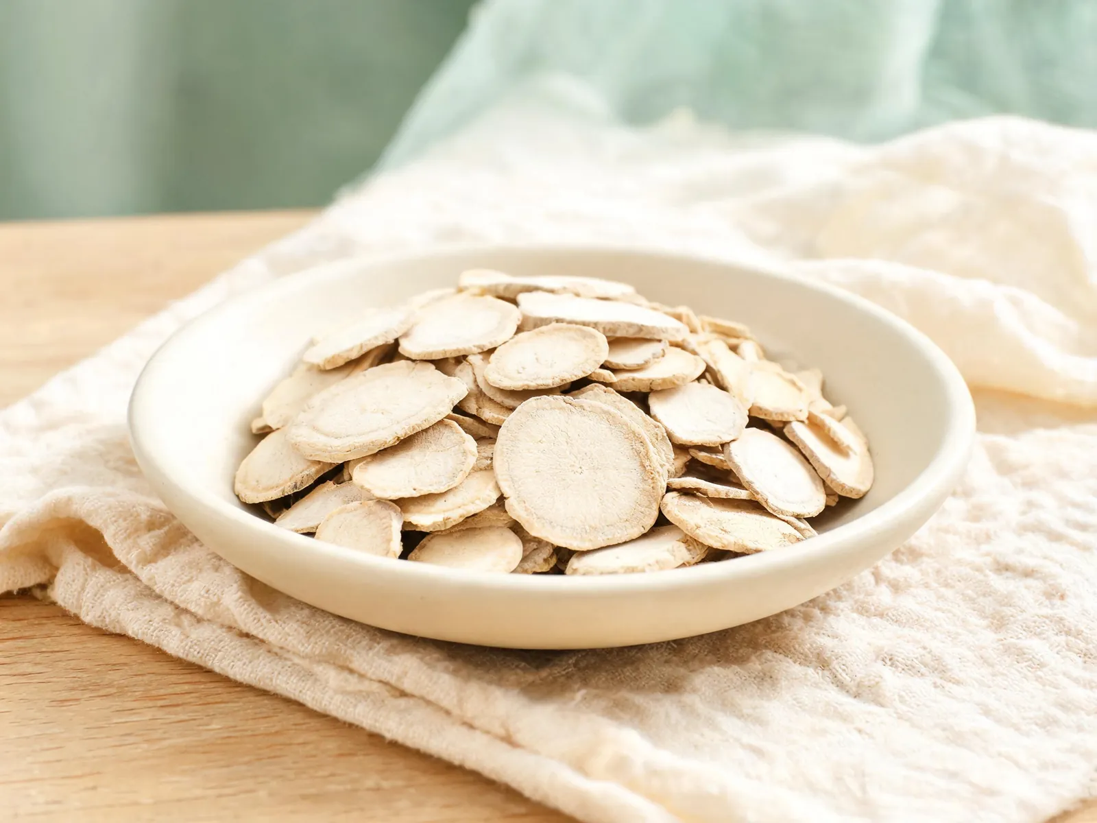 Dried processed tuber slices in a plain ceramic dish.