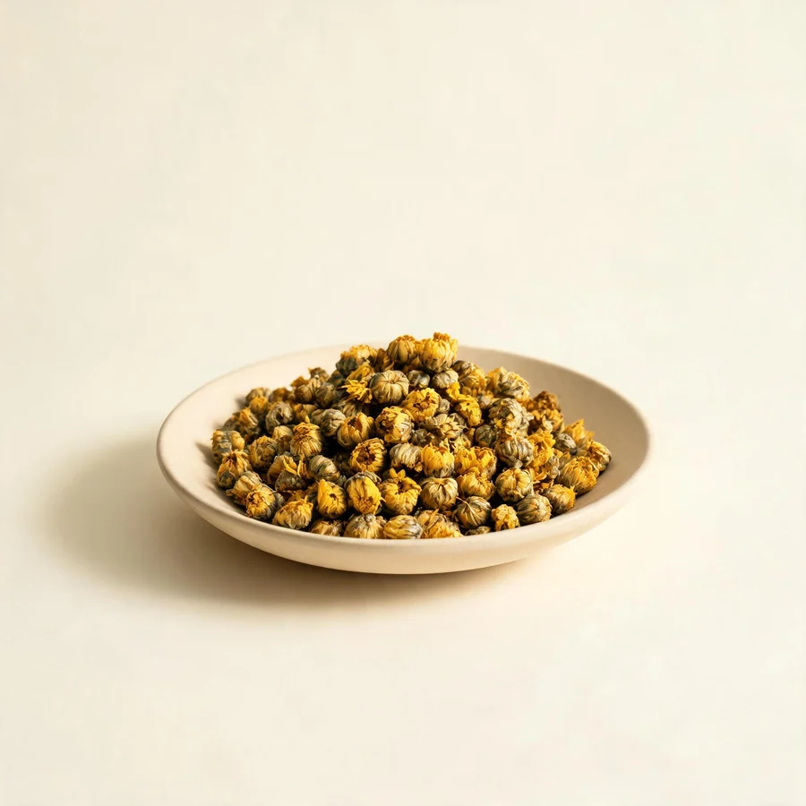 Dried Ye Ju Hua flower head arranged in a shallow bowl